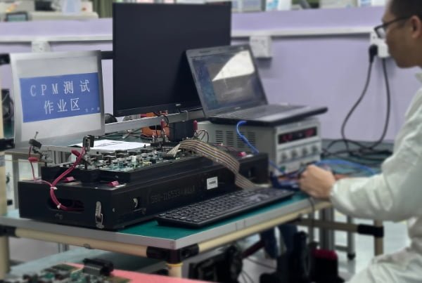 A technician performing a functional test on a PCBA before coating